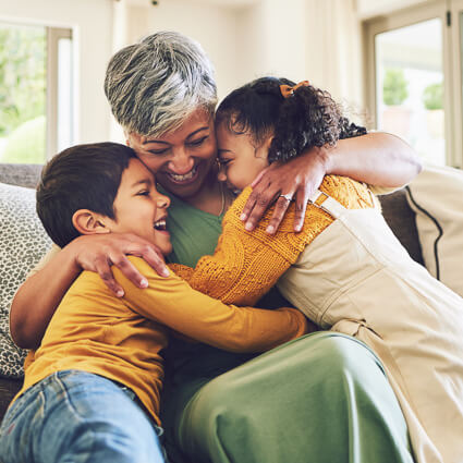 Grandmother hugging her grandchildren at home